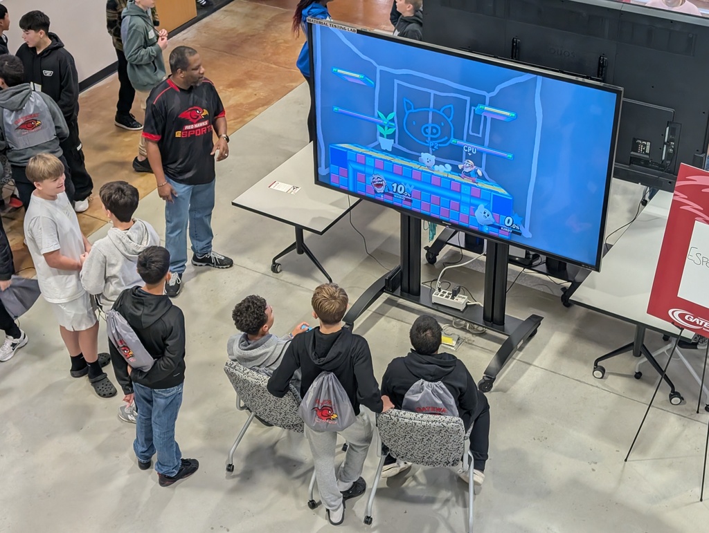 Several students learn about esports and play a video game against each other.