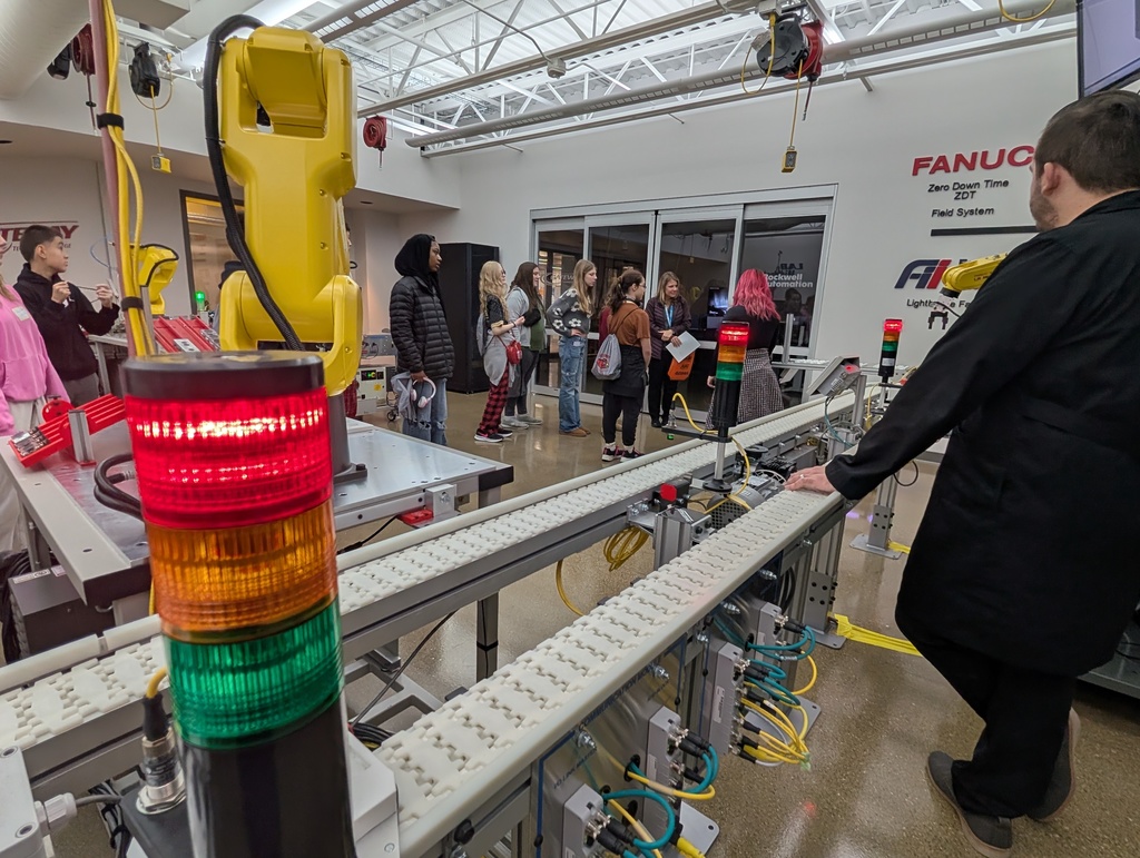 A group of students tour a robotics classroom.