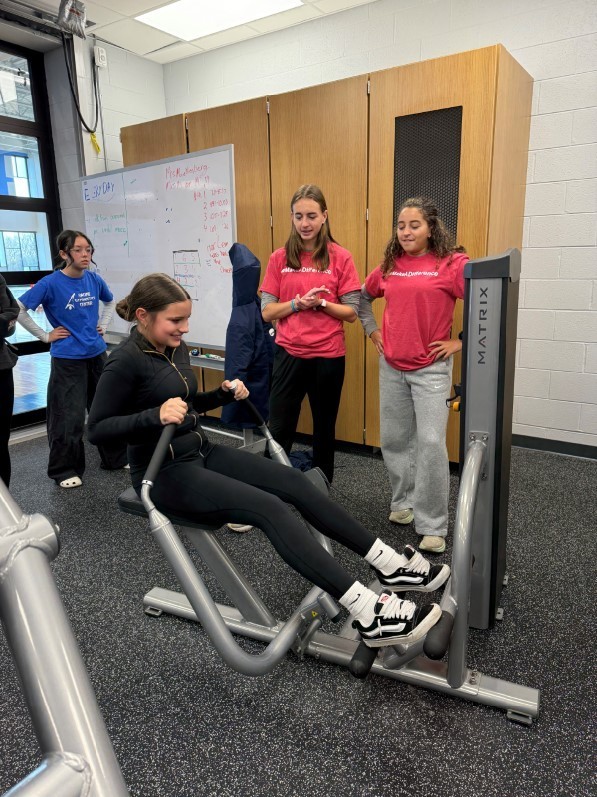 A student using a rowing machine.