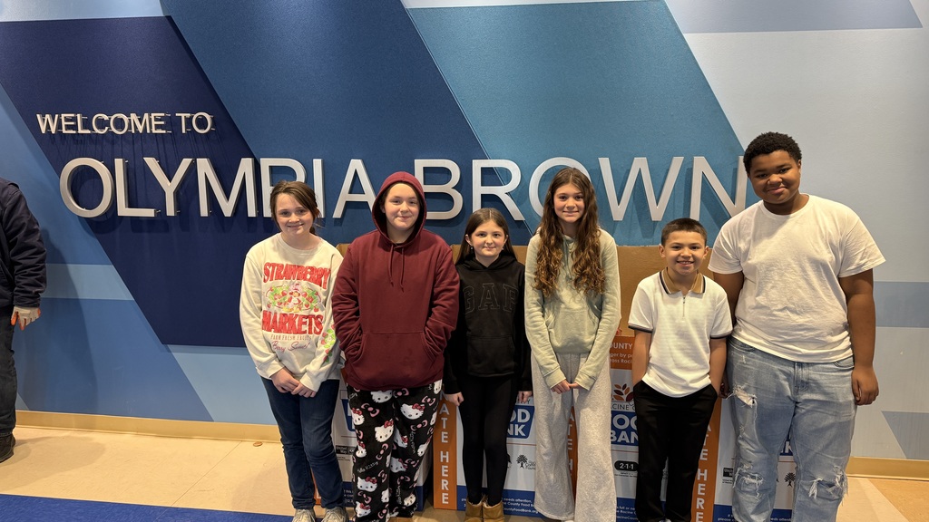 Olympia Brown School's student ambassadors pose for photo in front of the collected food donations.