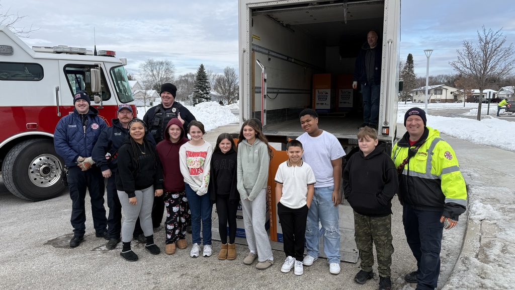 Olympia Brown's student ambassadors pose for a photo with Caledonia firefighters and a Caledonia police officer.