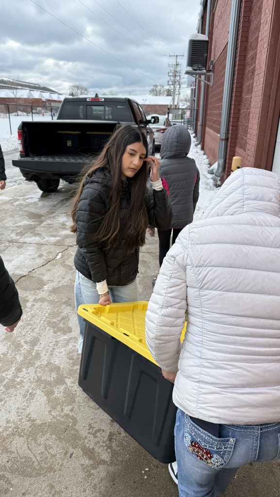Two female Mitchell students delivering a box of food to the Racine County Food Bank.