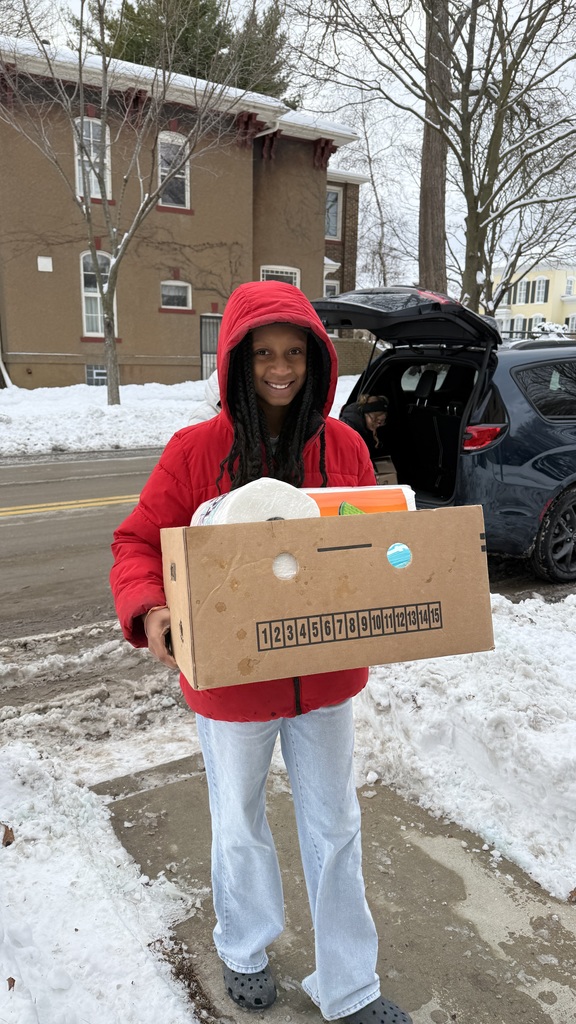 A female Mitchell student delivering a box of supplies to the Women's Resource Center.