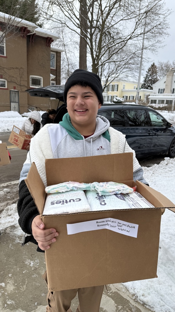 A male Mitchell student delivering a box of supplies to the Women's Resource Center.