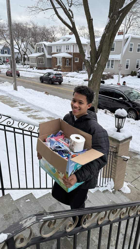 A male Mitchell student delivering a box of supplies to the Women's Resource Center.