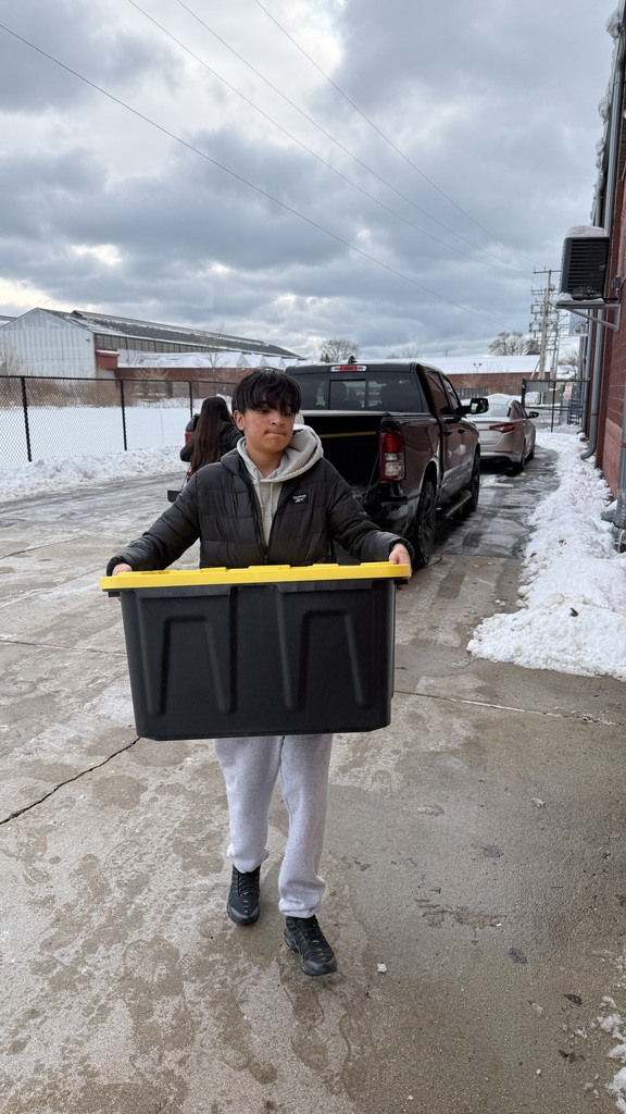 A male Mitchell student delivering a box of food to the Racine County Food Bank.