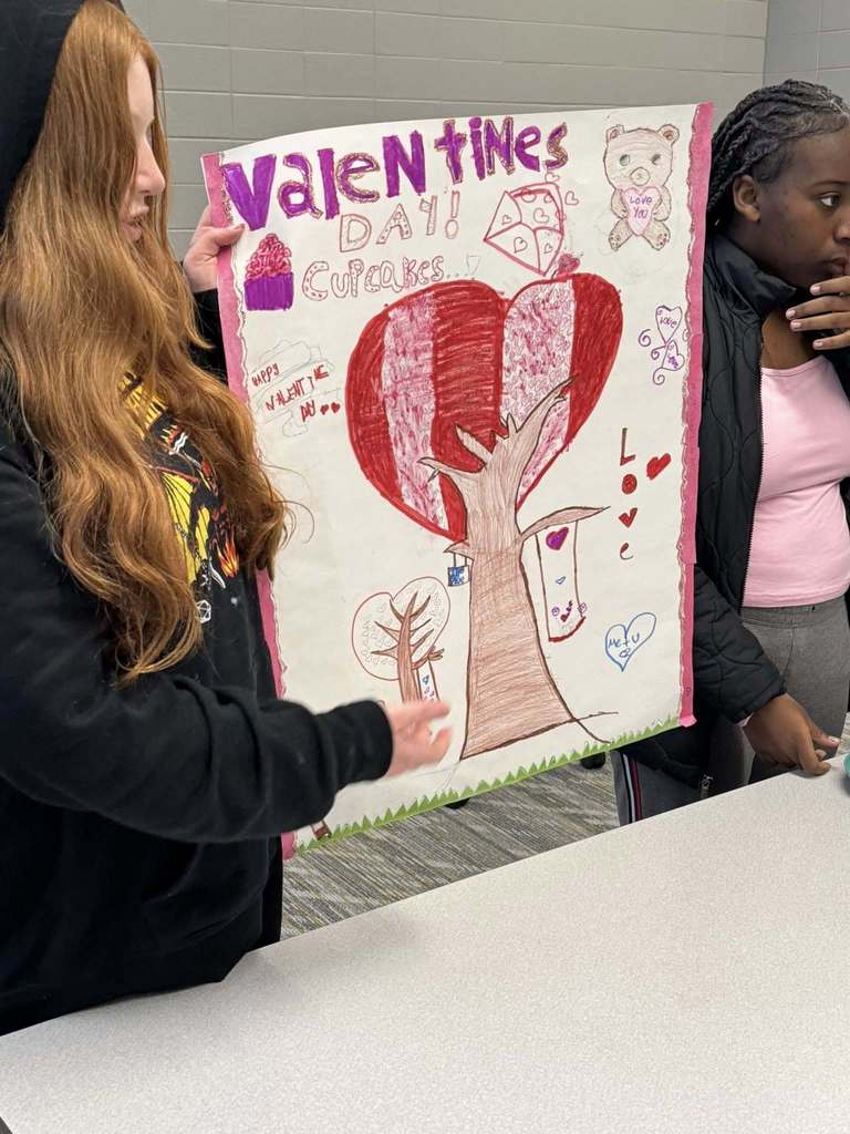 Students presenting their cupcake designs to the judging panel.