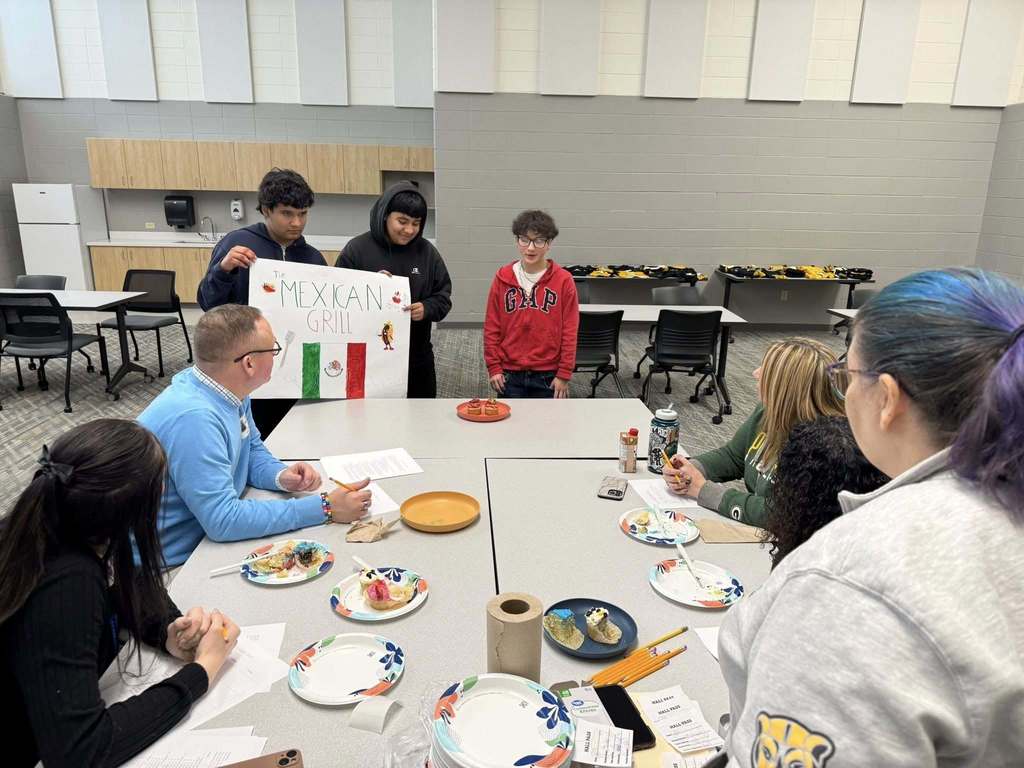 Students presenting their cupcake designs to the judging panel.
