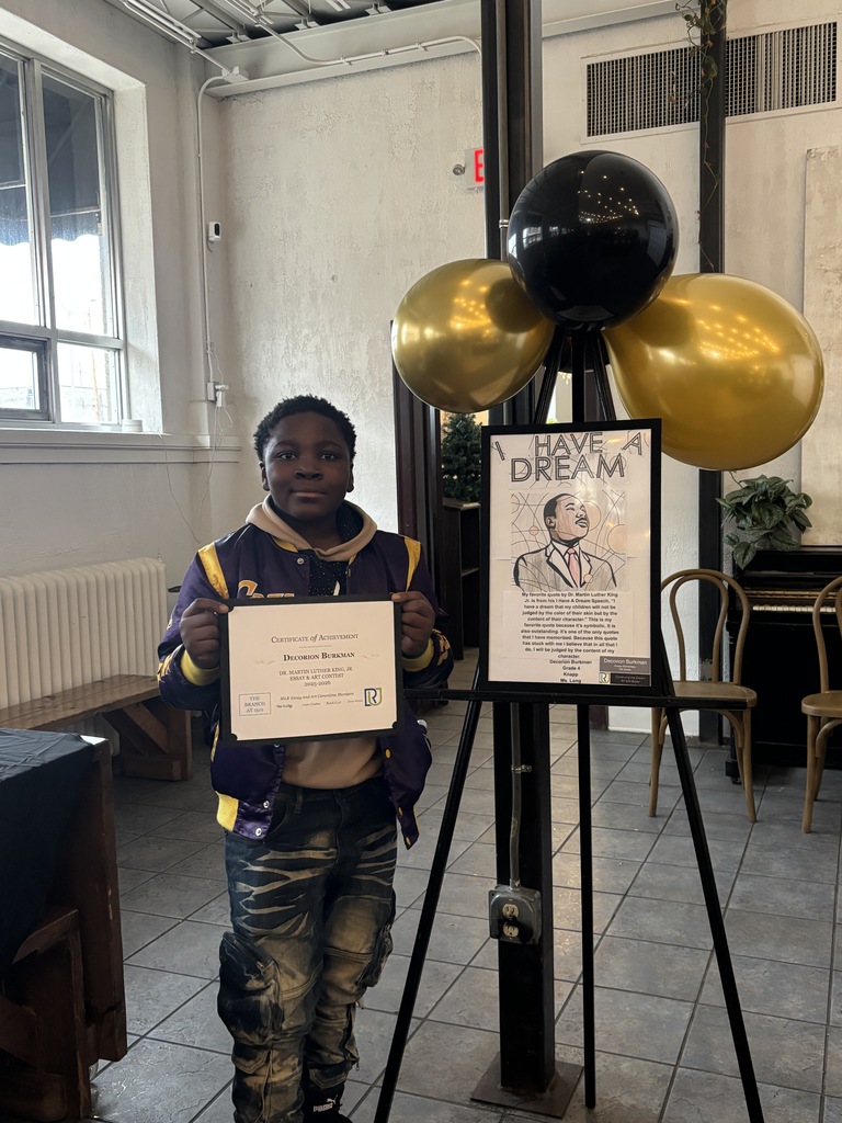 A student holding their award at this year's MLK Art and Essay awards show.