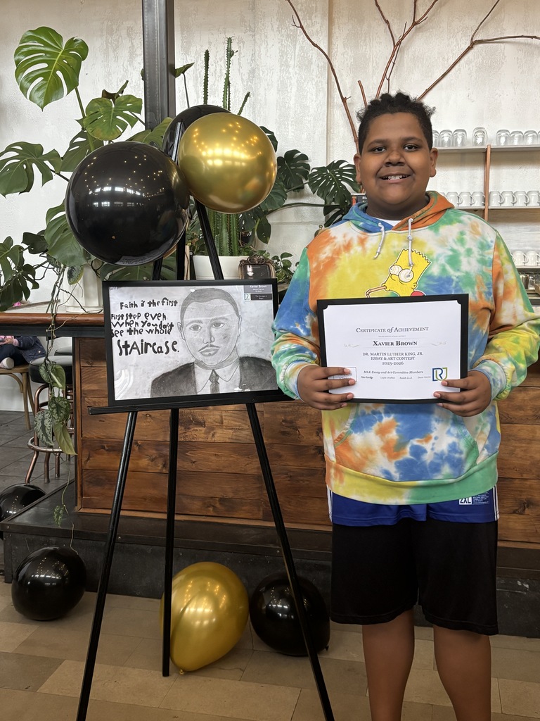 A student holding their award at this year's MLK Art and Essay awards show.