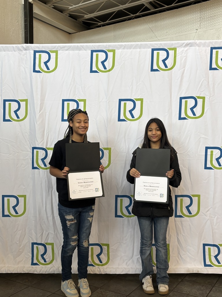 Two students holding their awards at this year's MLK Art and Essay awards show.