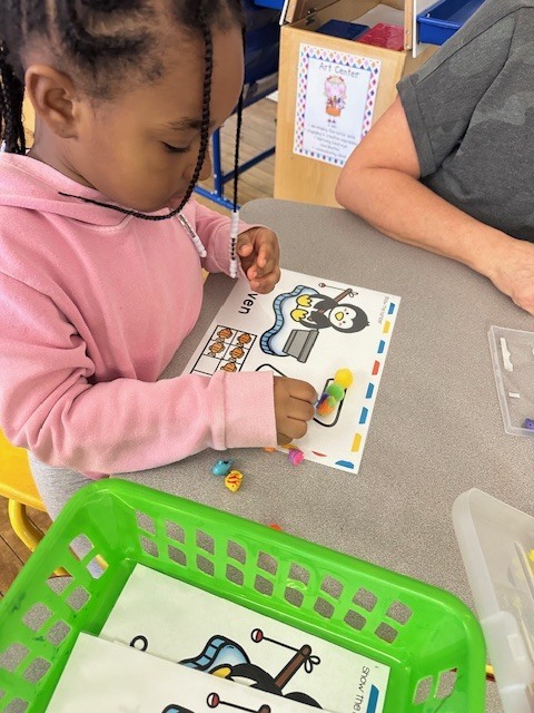 Picture of child practicing one to one correspondence  of the number 7