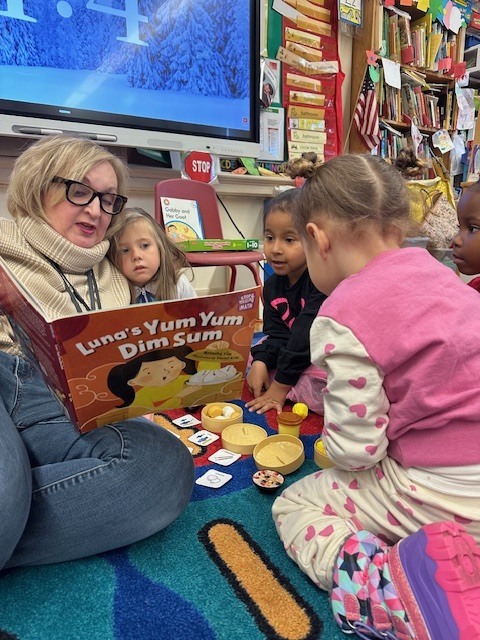 Teacher and students reading together.