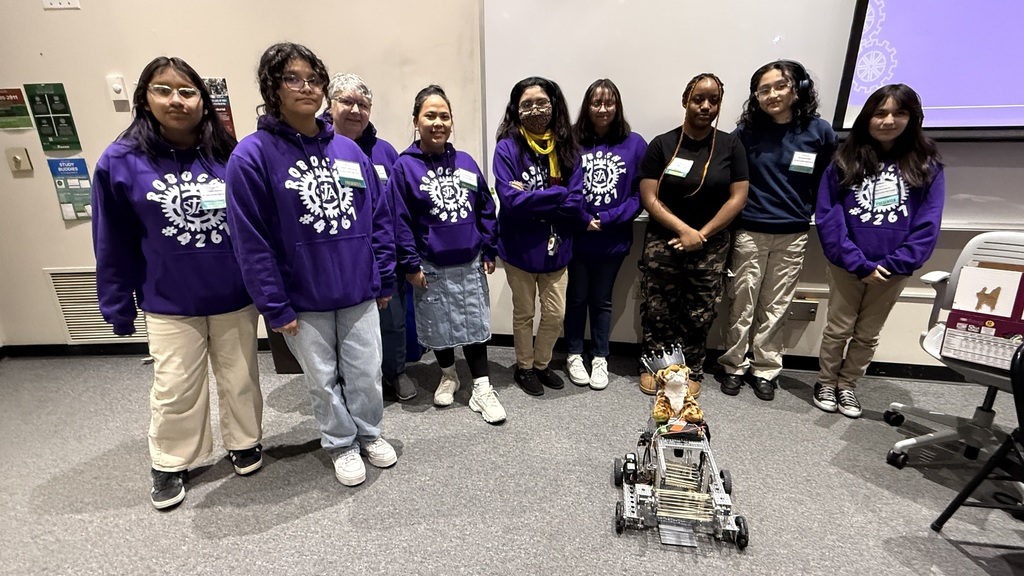 A group of student presenters from Walden, posing for a photo with a robot they built.