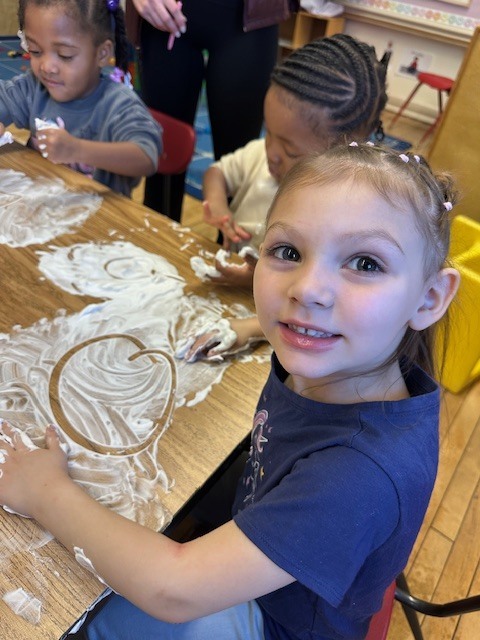 Students exploring letters using shaving cream.