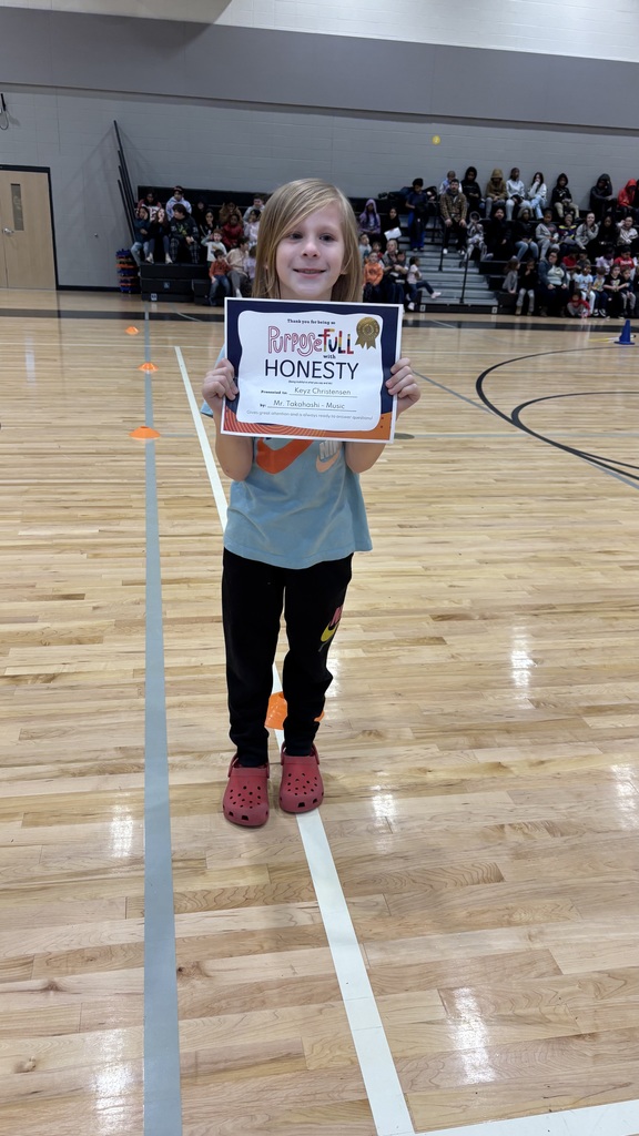 An elementary boy stands with his student of the month certificate celebrating his nomination for student of the month for exemplifying honesty in all they say and do!