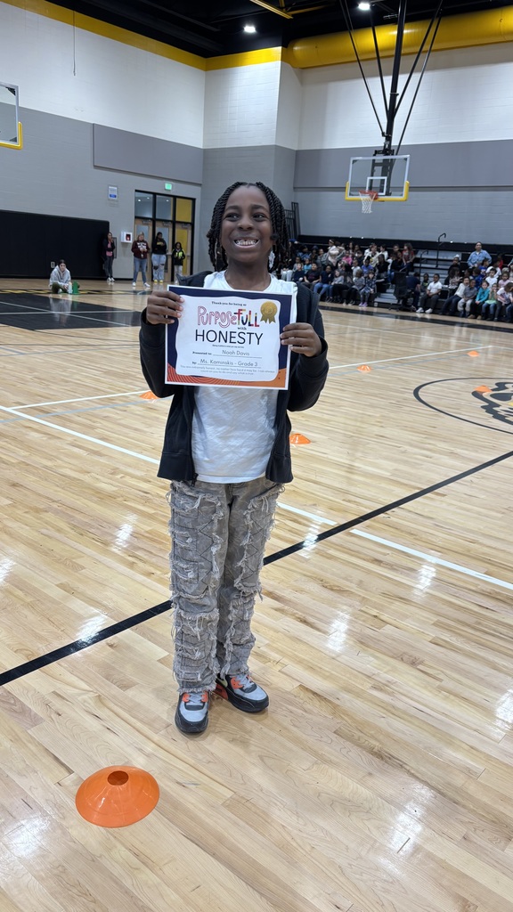 An elementary boy stands with his student of the month certificate celebrating his nomination for student of the month for exemplifying honesty in all they say and do!
