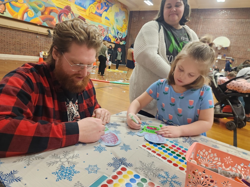 Father and daughter drawing together with mother watching over both of them.
