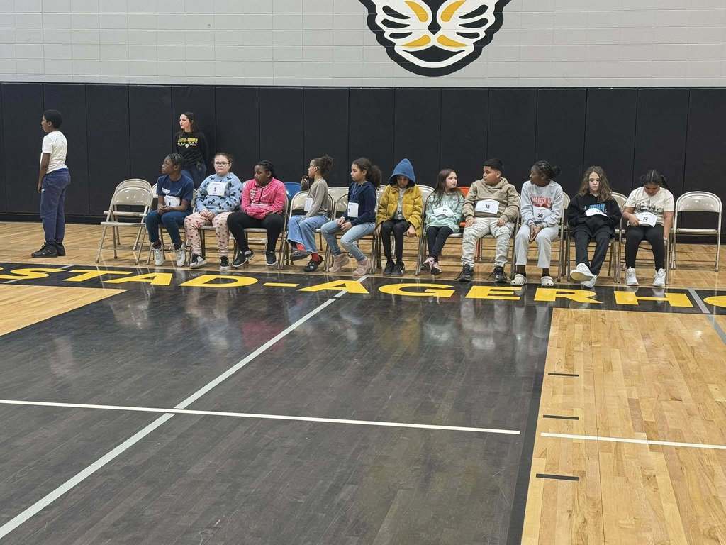 All of the students that made it past the first round of questions are seated in chairs. 