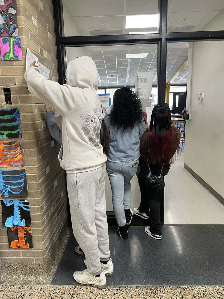 A group of students have found a scavenger hunt clue and are working on their assignment.