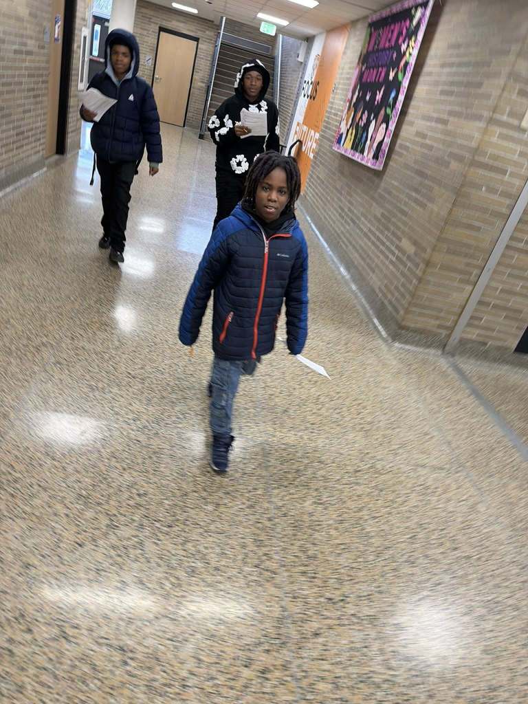 3 students walk in the hallway as they look for the next "clue."