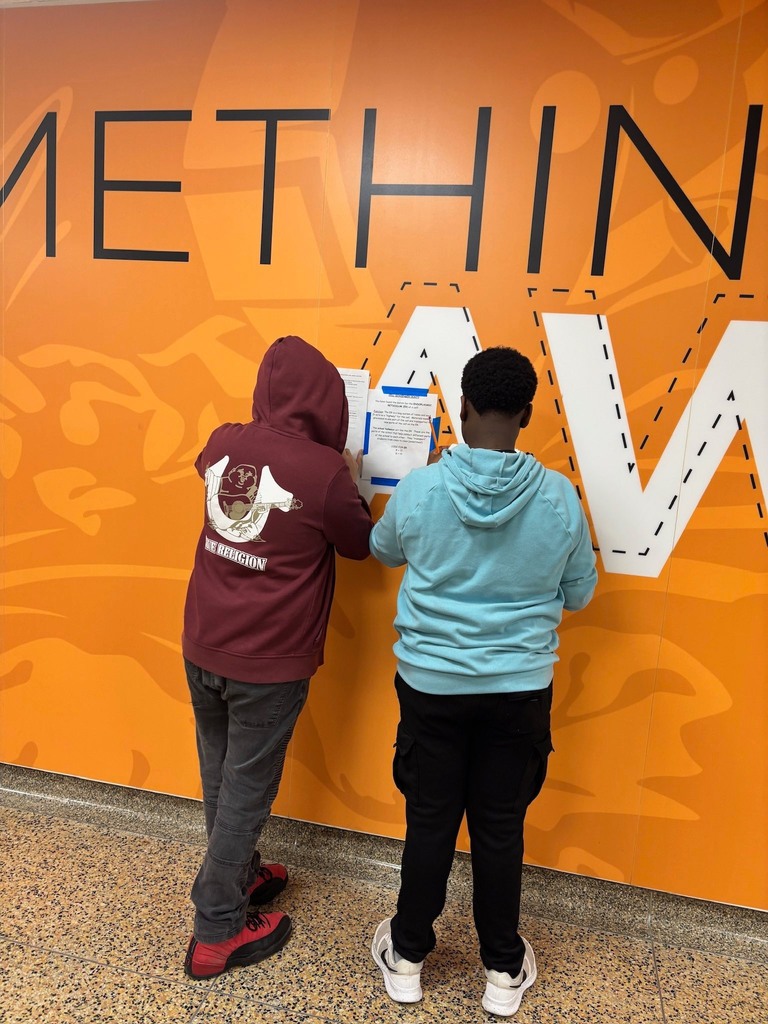 2 students have their backs to the camera as they work on completing the scavenger hunt.