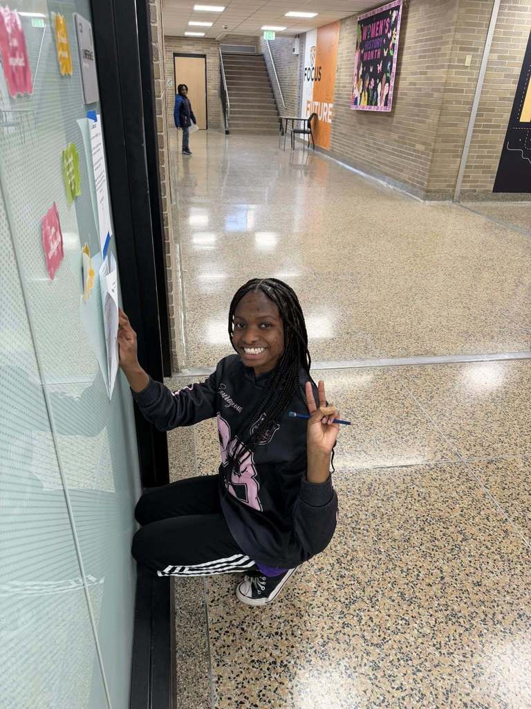 An 8th grade student poses for a picture while she is working on the scavenger hunt.