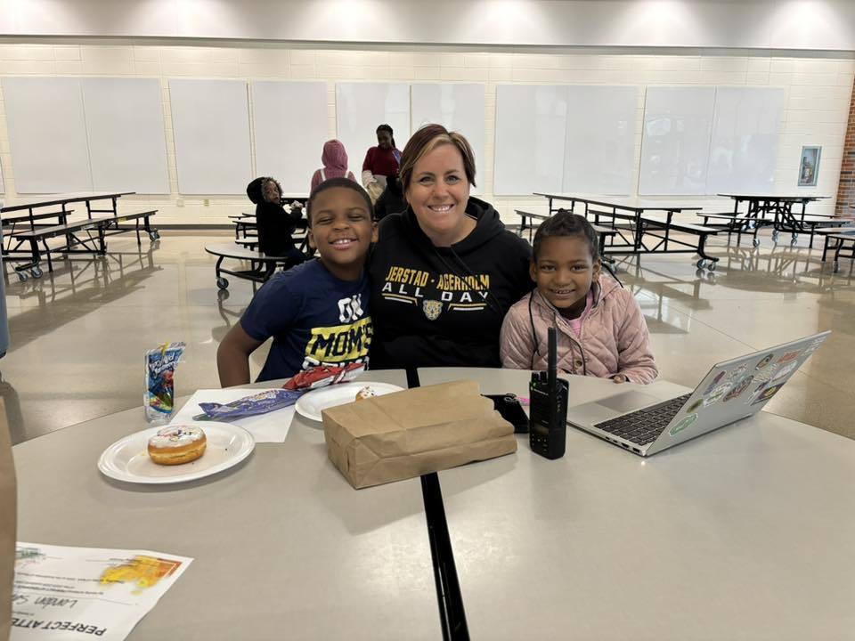A teacher celebrates her student receiving the perfect attendance award. 