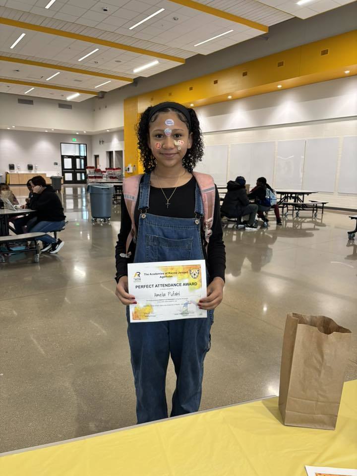 8th grade student holds her perfect attendance certificate