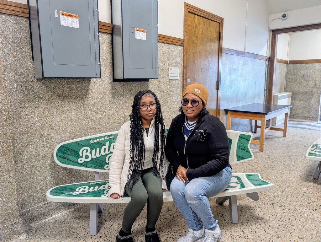 A middle school girl and a woman sit on the bench.