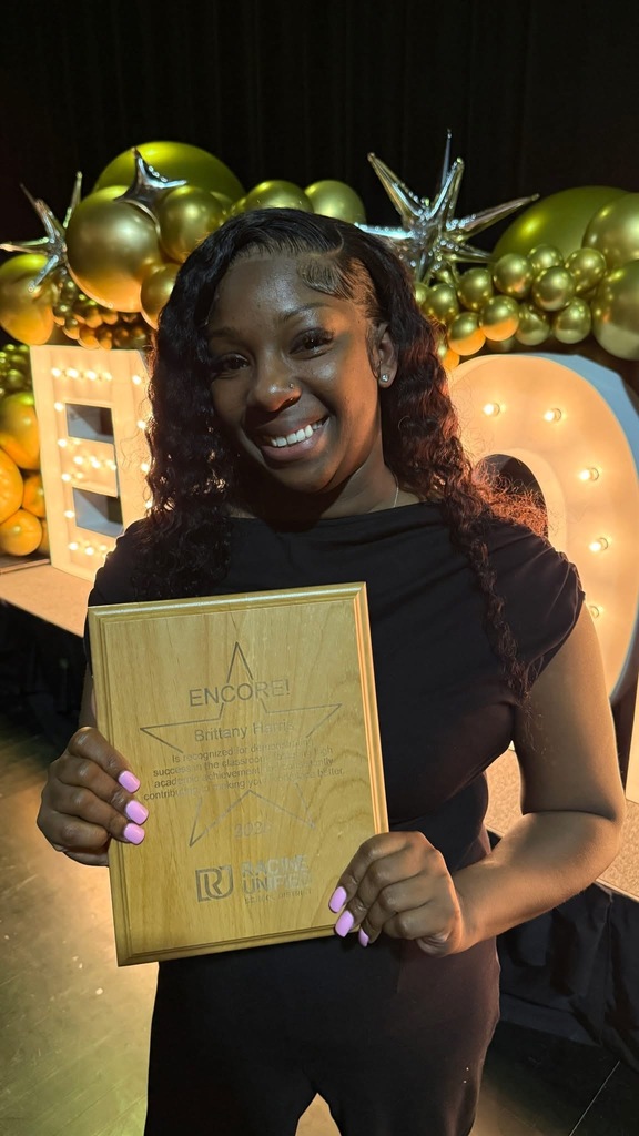 Woman holding plaque.