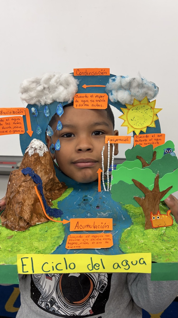 Student with a water cycle diorama in Spanish.