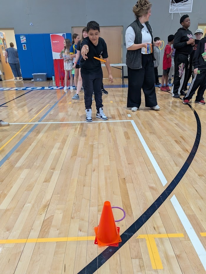 A male student playing a ring toss game.
