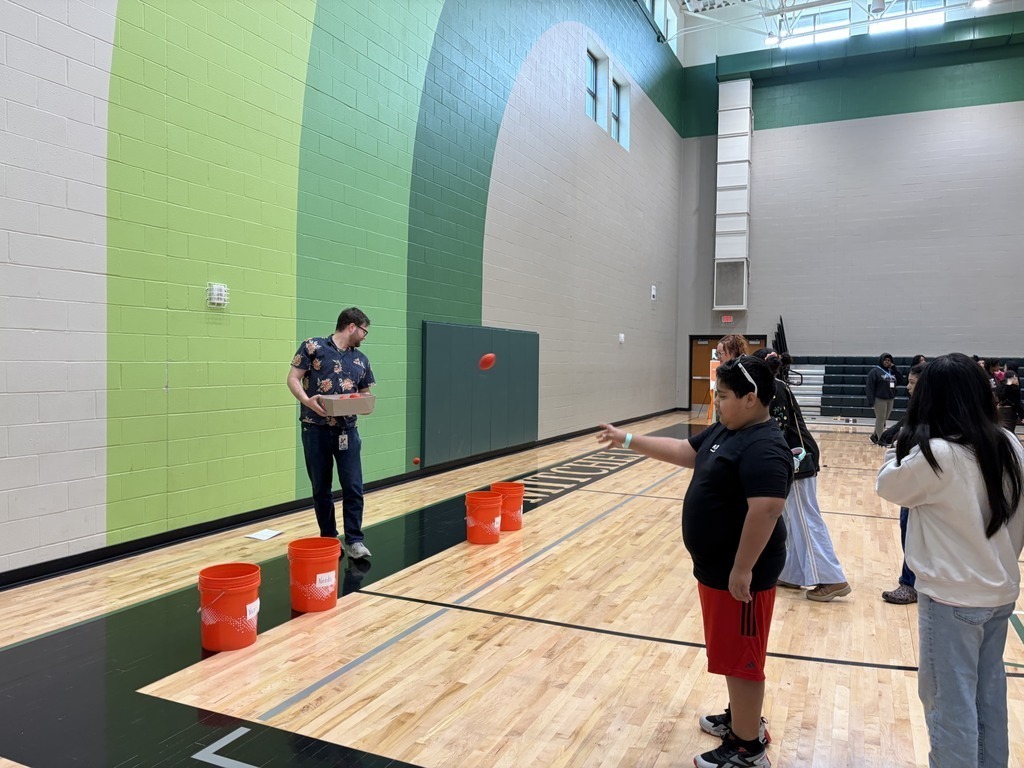A male student playing a bucket toss game.