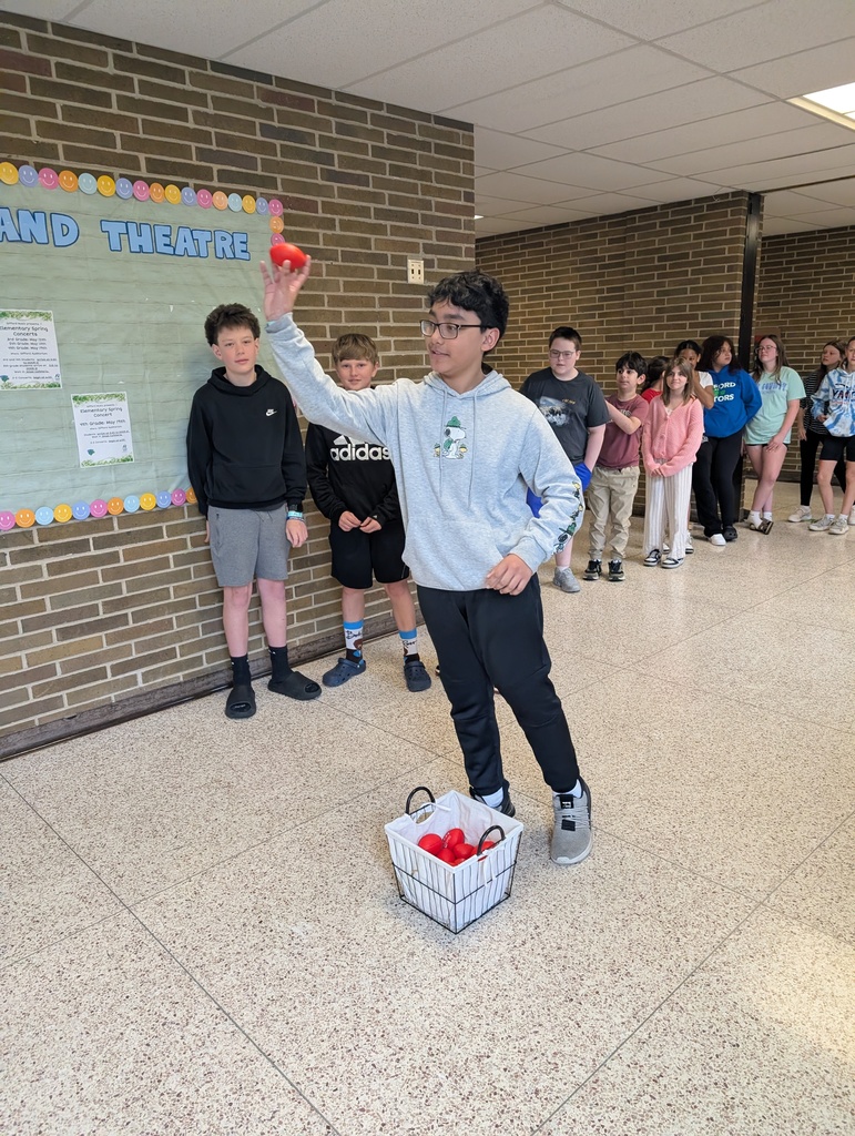 A male student throwing a small red football.