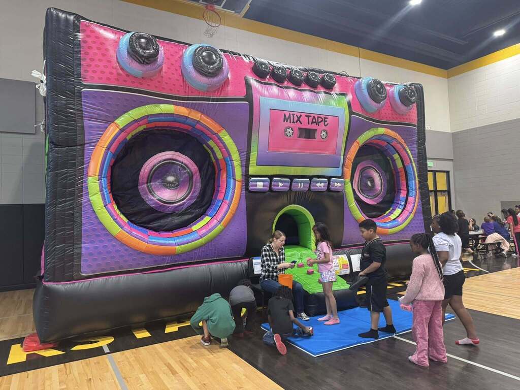 80s boombox bouncy house with students waiting in line.