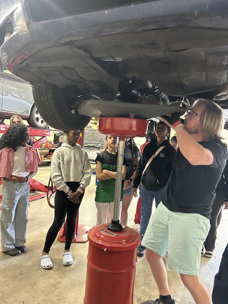 Park's automotive instructor demonstrating how to remove engine oil.
