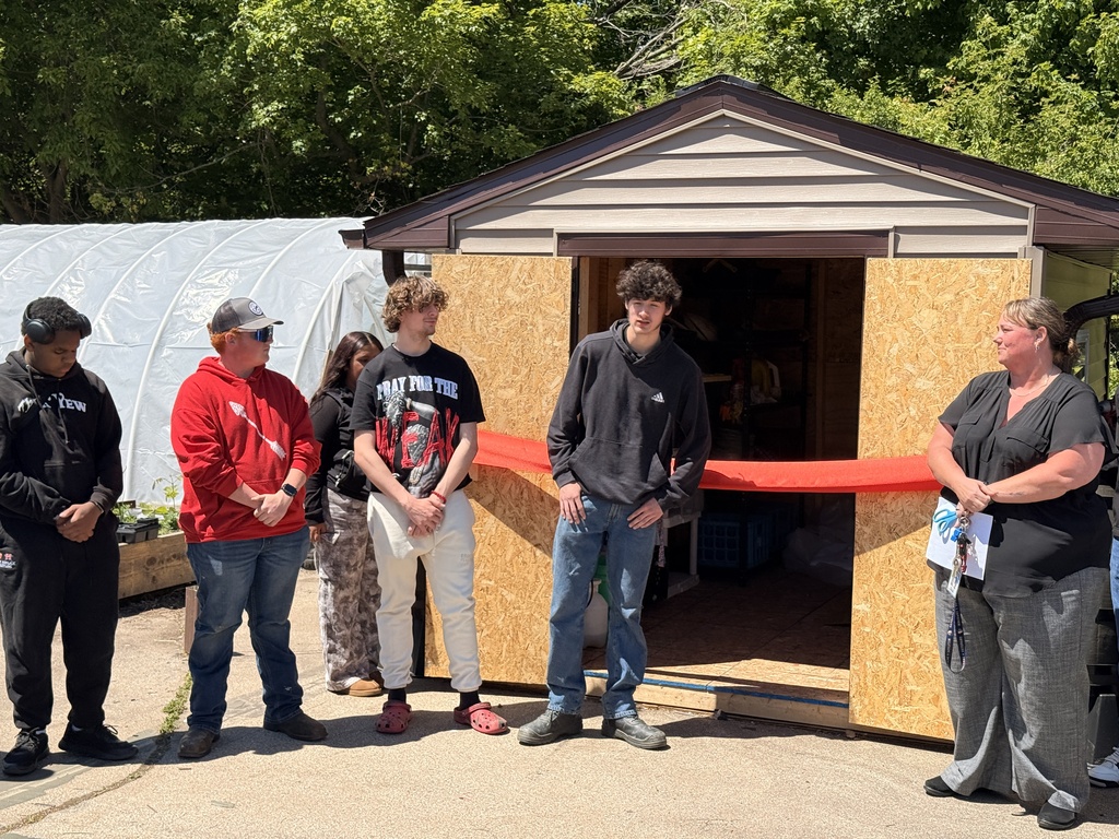 A student who worked on the project speaks in front of the storage shed.