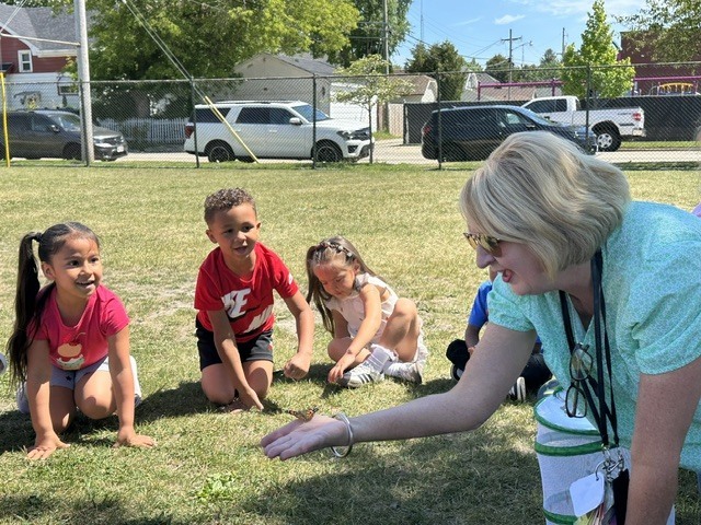 Excited prek students watch as butterfly takes flight.