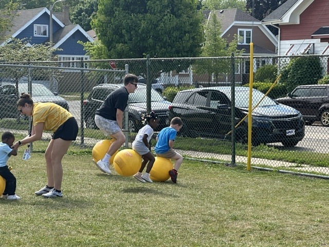 Students on bouncy balls with teachers.