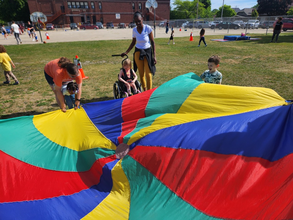 Students and staff playing with colorful parachute.