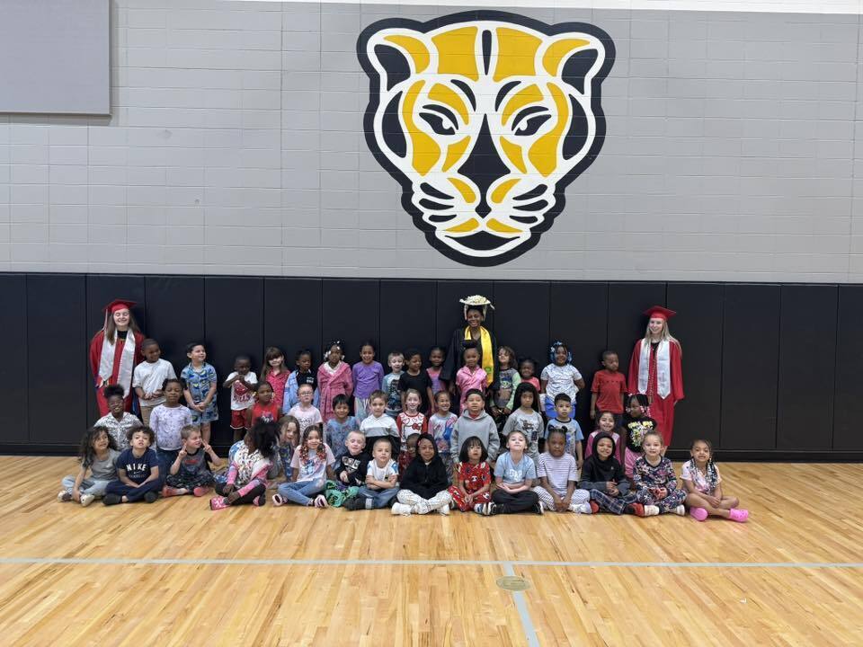 All the kindergarten students pose with the graduating seniors.