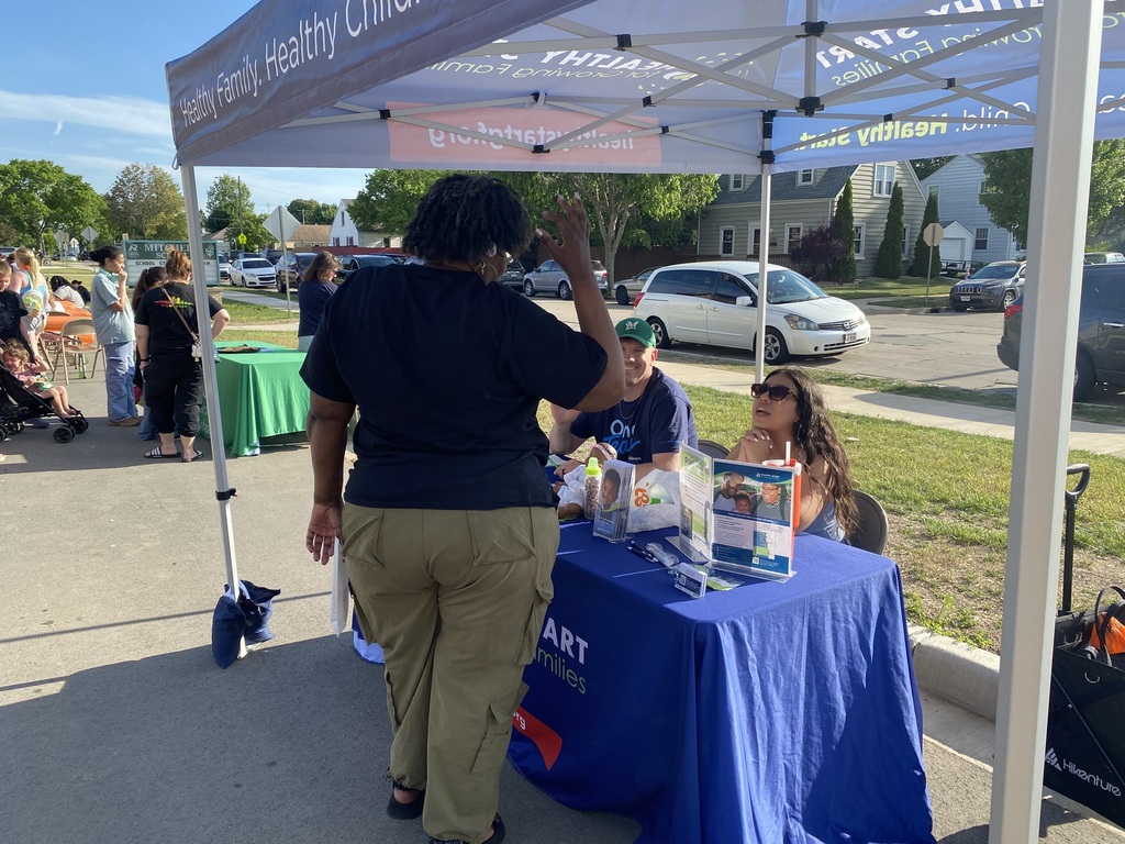An adult speaks with a partner organization.