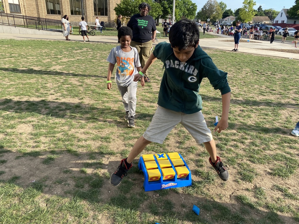 Two young boys playing an outdoor version of tic tac toe.