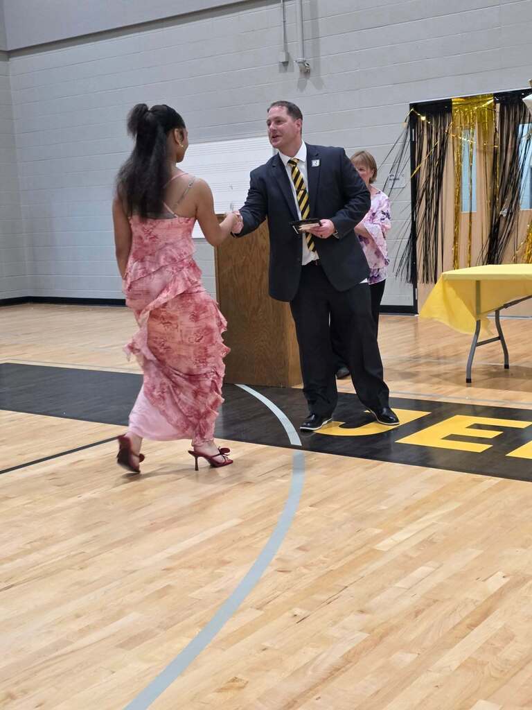 8th grade student receives an award from Mr. Paproth