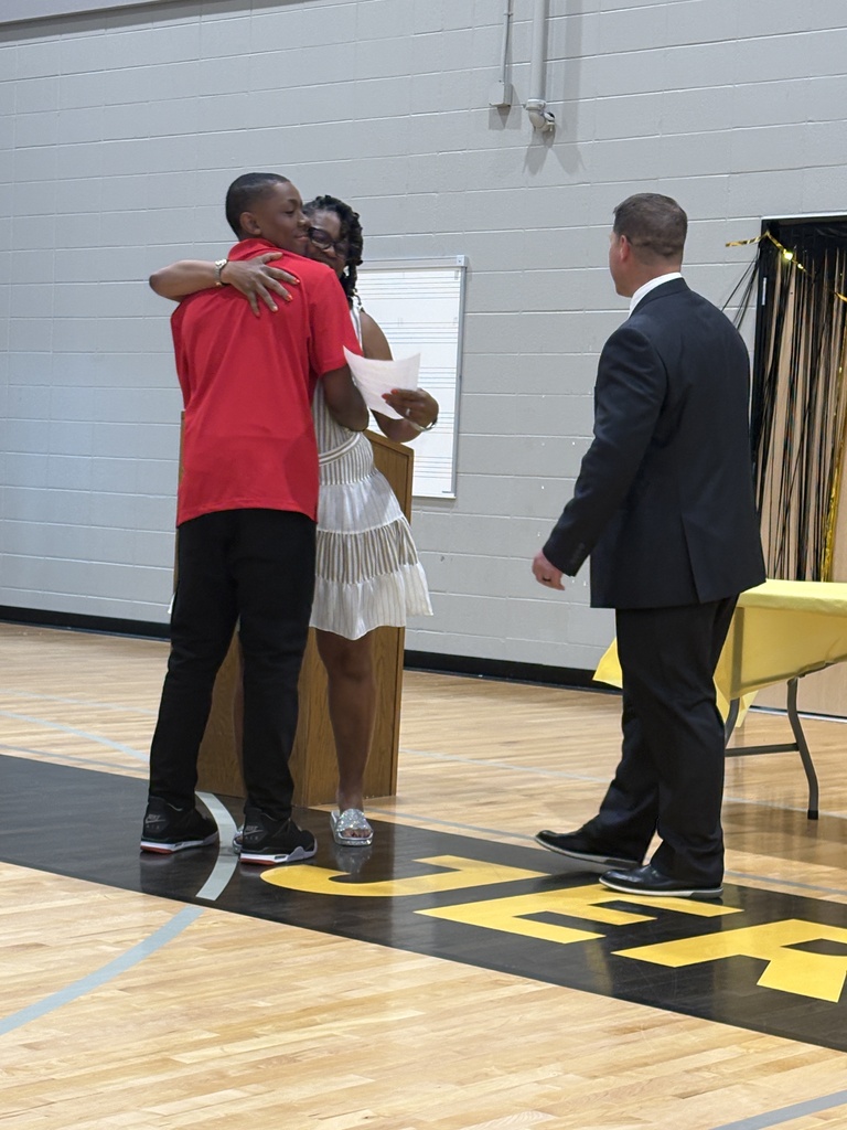8th grade student receives an award from Ms. Ann