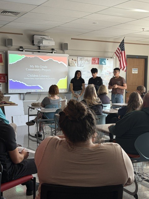 Three students give a classroom presentation on Children's Literacy.
