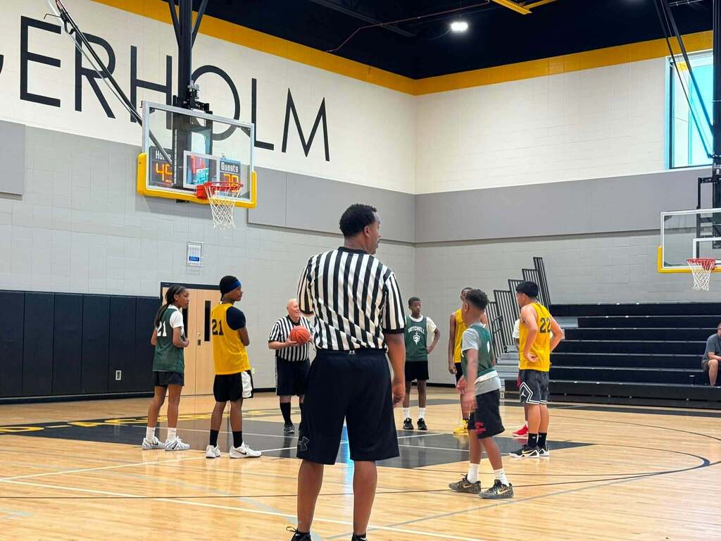 Jerstad and Mitchell basketball players on the court.