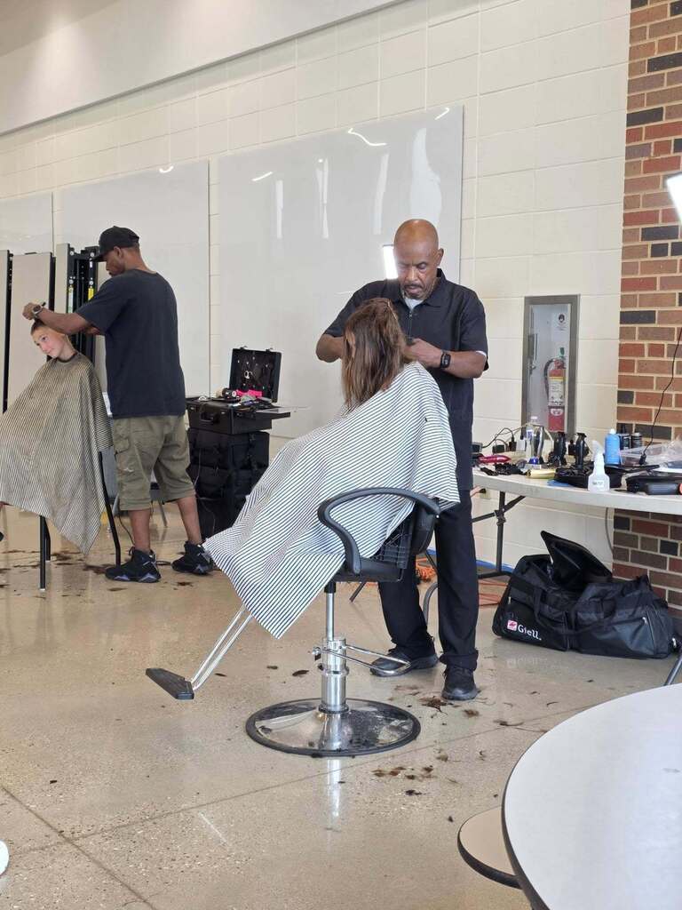 2 students getting their hair cut.
