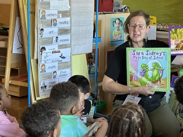 Teacher uses story book and nonfiction book to compare iquanas.